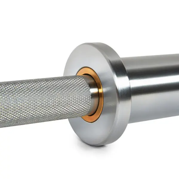 Close-up of the ATX® Warrior Power Bar IPF featuring a silver barbell with a knurled grip and smooth sleeve, complete with a golden collar at its base to enhance the sleek, professional design.