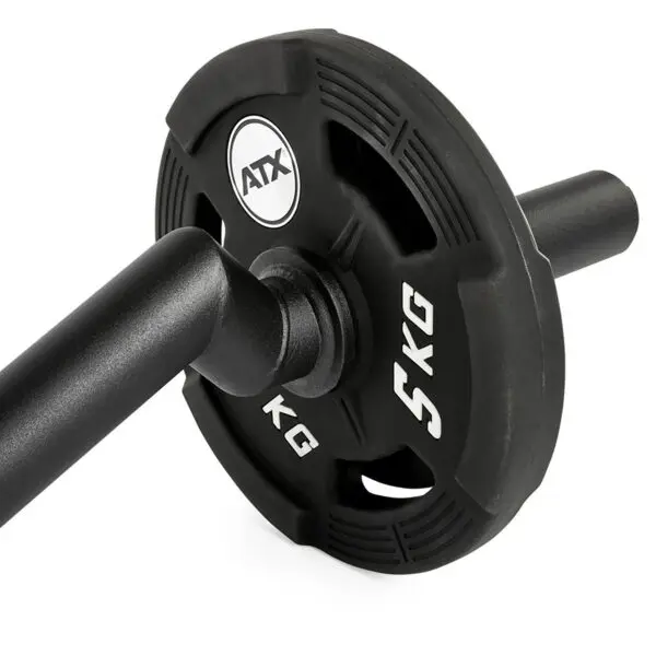 Close-up of a black FAT EZ Curl Bar weight plate labeled 5 KG, mounted on a barbell. The plate features cut-out handles for easy grip.