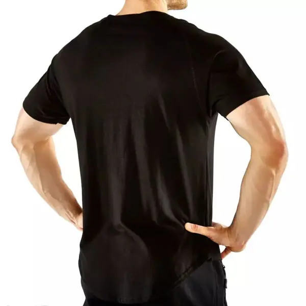 An individual in an ATX® Training Shirt BLACK faces away from the camera, hands on hips. The shirt fits snugly, emphasizing their physique against a plain white backdrop.