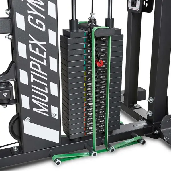 Close-up of a weight stack on the ATX® MultipleX Multi Gym - 700. The stack includes plates from 5kg to 20kg with color-coded markers for different weights, and green cables for resistance training.