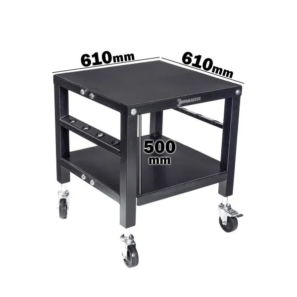 The Ironmaster QLDB Stand PRO is a black wheeled table with a square top measuring 610mm by 610mm and stands 500mm high. It includes a lower shelf for storing Ironmaster adjustable dumbbells and is labeled WORKMASTER on the side.