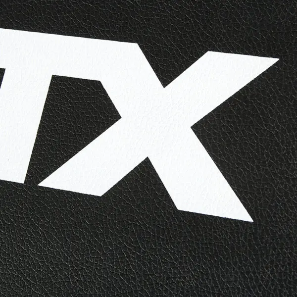 Close-up of a black textured surface on the ATX® Commercial FID Bench ATX-MBX-660, featuring large white TX letters boldly printed on it.