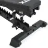 A close-up of the ATX® Commercial FID Bench ATX-MBX-660 reveals its sturdy black metal frame with ridged footrests for versatile workouts. This bench features a padded seat designed for flat and incline exercises with ATX marked in white.