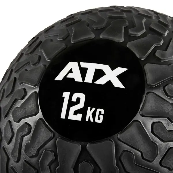 Close-up of an ATX® Slam Ball with a textured black surface and a rugged pattern. The brand ATX and weight 12 KG are displayed in white on its smooth circular patch.