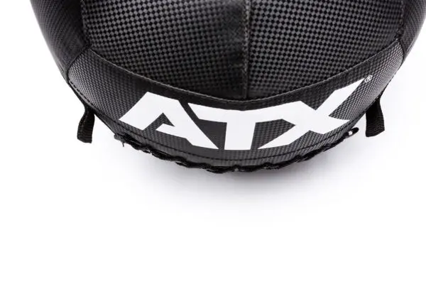 A close-up of a black and gray textured ATX® Wall Ball PVC shows ATX in white. The ball features stitching details and black straps, set against a white background.