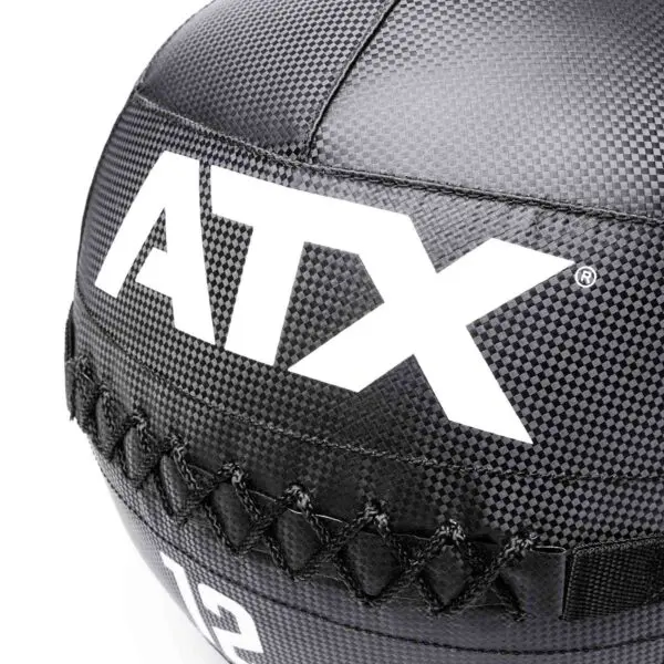 Close-up of a black textured ATX® Wall Balls PVC medicine ball, featuring bold white ATX initials and visible cross-stitch detailing for a durable look.