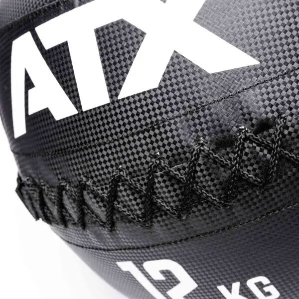 Close-up of a black and white ATX® Wall Balls PVC with the letters ATX, a visible stitched seam, and a textured grid-like pattern. The ball is weighted at 12 kg.