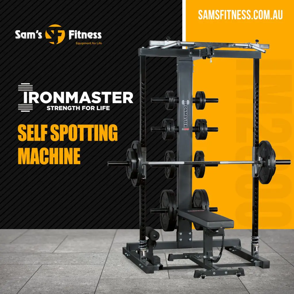 A self-spotting weight machine with barbells is displayed on a gray floor. The text reads “Ironmaster Strength for Life, Self Spotting Machine.” Branding for Sam’s Fitness appears at the top left and in the upper right corner.