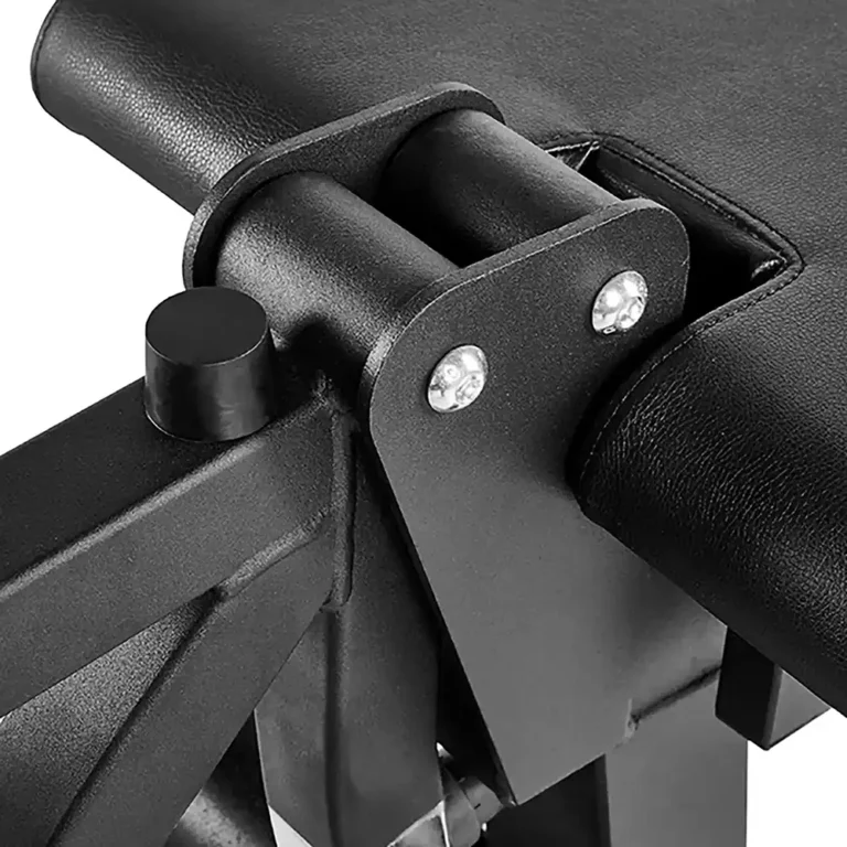 Close-up of a black hinge on the ATX Leg Extension Leg Curl Machine, showcasing metal parts and screws. The bench features smooth black padding, perfect for strength training or exercise.