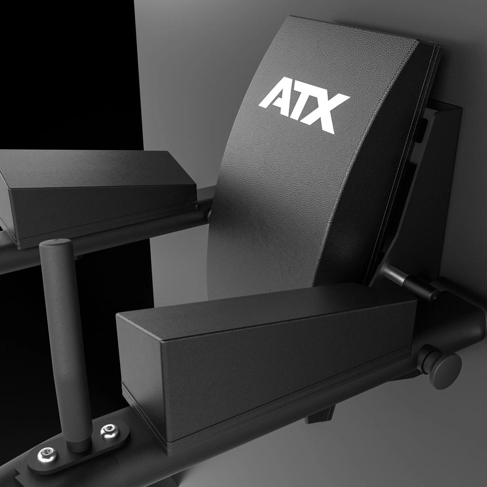 Close-up of a black gym bench with ATX in white letters on the backrest, featuring arm and leg pads, handles, and a metallic frame against a dark background—perfect for pairing with the ATX® Wall Mounted Knee Raise & Dip to elevate your strength training routine.
