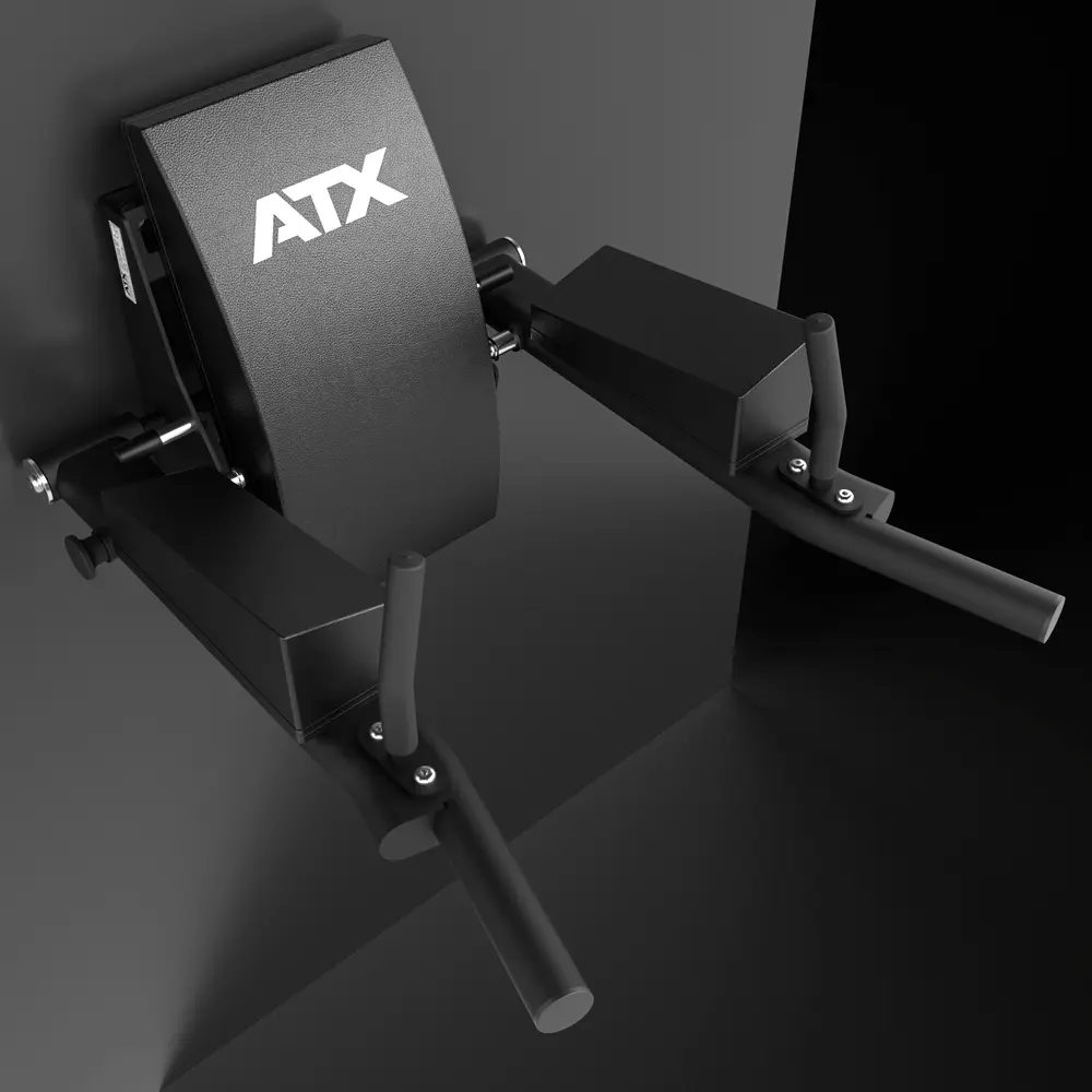 A close-up of the ATX® Wall Mounted Knee Raise & Dip, a black gym station attached to a wall, featuring padded armrests and angled handles designed for tricep dip exercises as well as knee raise workouts.