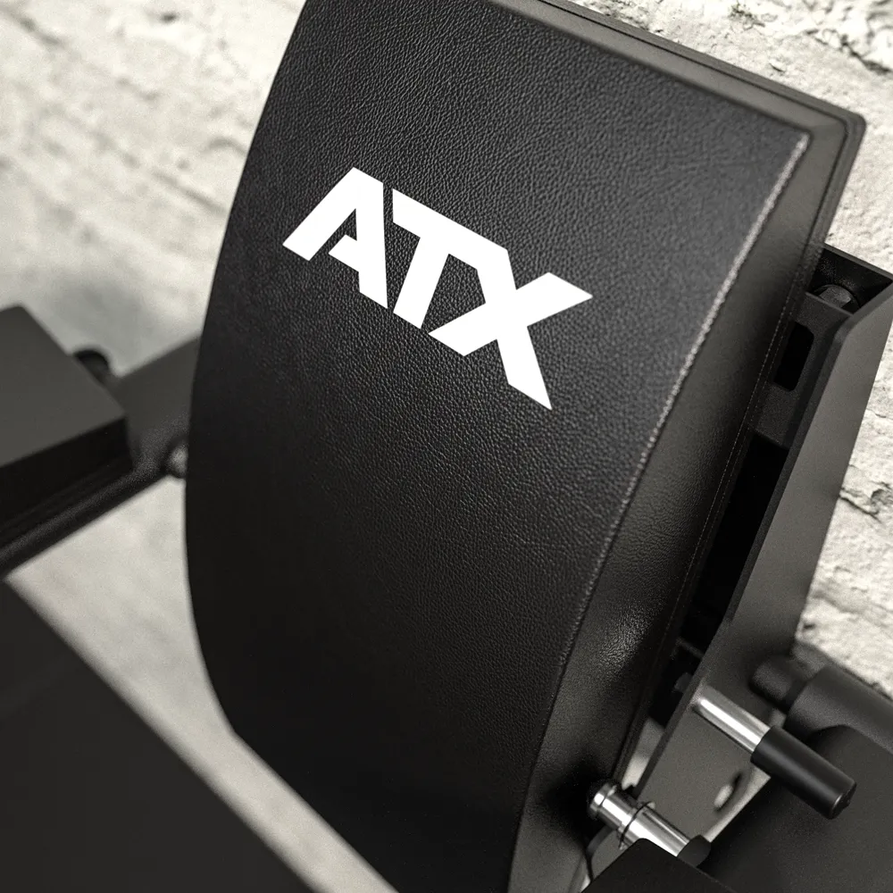 Close-up of the black padded backrest of the ATX® Wall Mounted Knee Raise & Dip, featuring white ATX lettering, securely mounted on a textured light-colored wall with visible bolts and adjustment mechanisms, designed for wall-mounted knee raise and dip exercises.