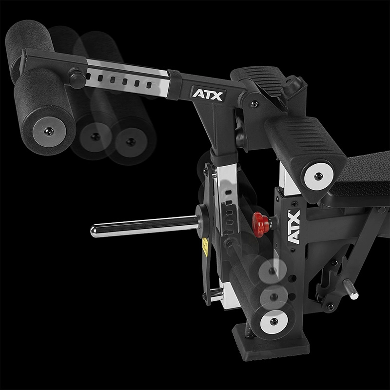 Close-up of an ATX Leg Extension/Leg Curl Attachment on a black ATX adjustable gym bench, featuring padded rollers, metal adjustment rods, and visible branding against a black background.