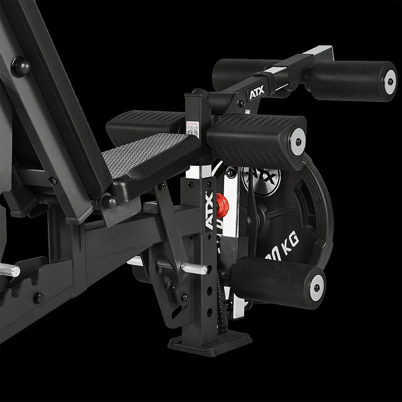 Close-up of the ATX Leg Extension/Leg Curl Attachment with padded rollers, leg extension feature, 20 kg weight plate, textured grips, and a sturdy metal frame, all set against a black background.