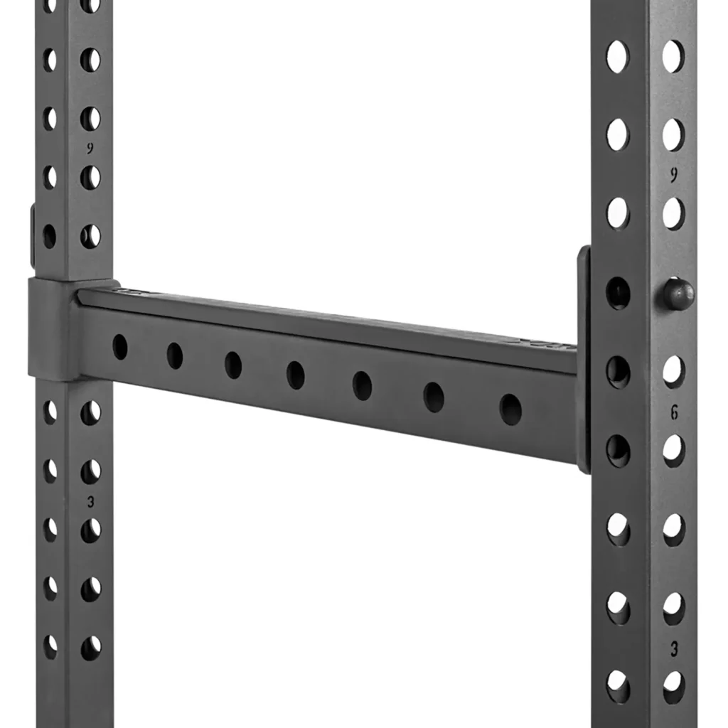 Close-up view of a black adjustable crossbar on the ATX® Power Rack 520 215cm, featuring numbered holes on a metal frame for height adjustment, suitable for gym or storage purposes.