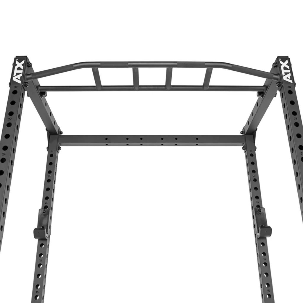 A close-up view of the ATX® Power Rack 520 215cm shows a metal pull-up bar attached to its black frame, which features multiple holes. Designed for strength training and exercises, the brand ATX is visible on the rack.