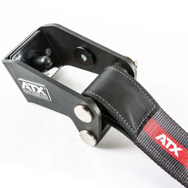 Close-up of a black ATX® Safety Strap System featuring a durable strap secured through a metal loop. It showcases sturdy construction ideal for fitness equipment, with the ATX logo visible on both the device and strap.