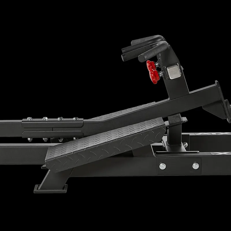 Close-up side view of the ATX® T-Bar Row Machine footplate and adjustable footrests, featuring a red adjustment knob and textured surface, set against a solid black background.