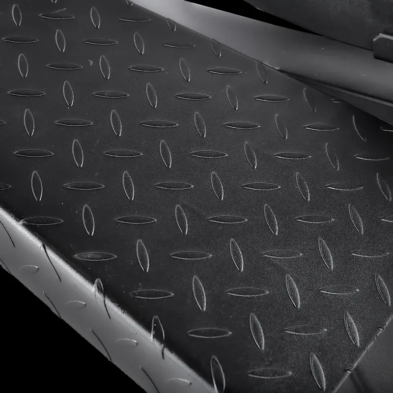 Close-up of a black metal surface with a raised oval tread pattern, similar to that on the ATX® T-Bar Row Machine, designed for optimal slip resistance.