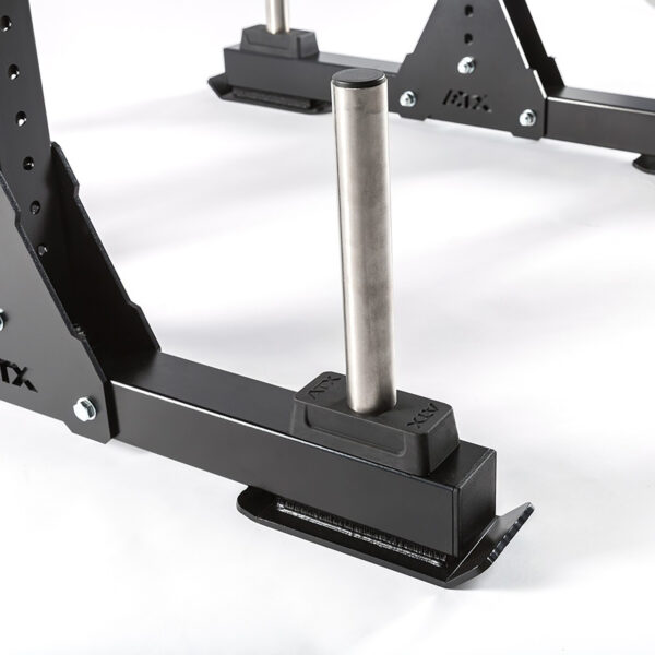 Close-up of a black metal gym part, showcasing a cylindrical steel peg on a rectangular base with a support structure, resembling components from the discontinued ATX® Bulls Strongman Yoke. Ideal for plate storage or weightlifting rack usage.