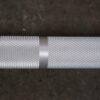 Close-up of the Aluminium 7.5kg Technique Olympic Bar featuring a textured, diamond-patterned grip and a smooth center band, set against a dark background.