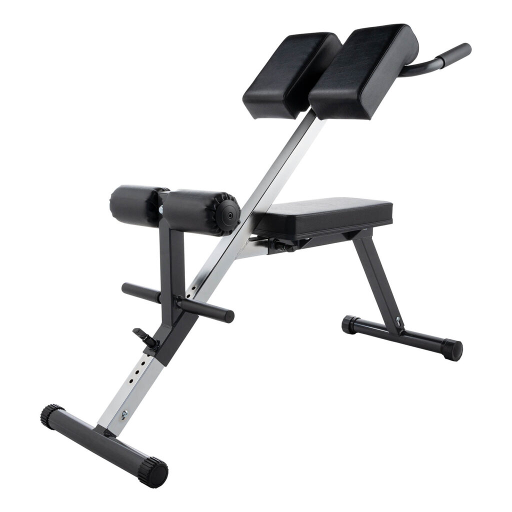 The Ironmaster Hyper Core Attachment is a black and silver extension bench with padded leg supports and an angled hip pad. It features a sturdy, foldable design with adjustable height and a supportive base, perfect for gym or home use.