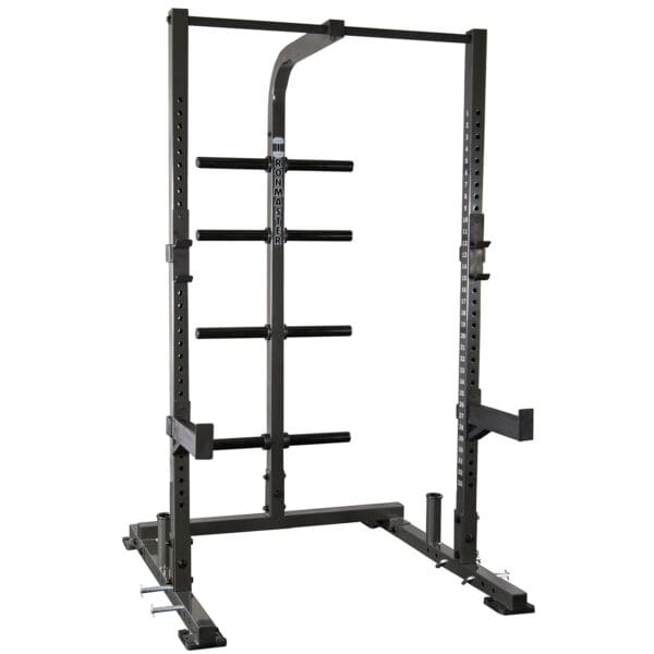 The IM1500 Ironmaster Half Rack is a black power rack featuring adjustable safety bars, multiple weight storage pegs, a top pull-up bar, and adjustable j-cups for barbell support. It is set against a white background.