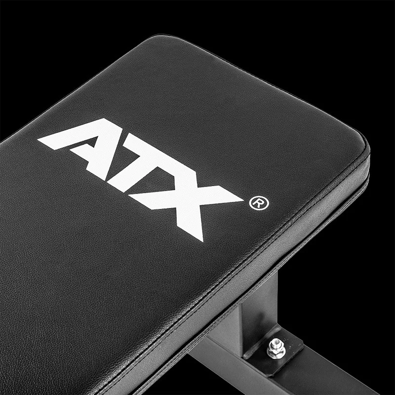Close-up of an ATX® Flat Bench PRO, featuring a black flat exercise bench with a white logo printed on the top pad.
