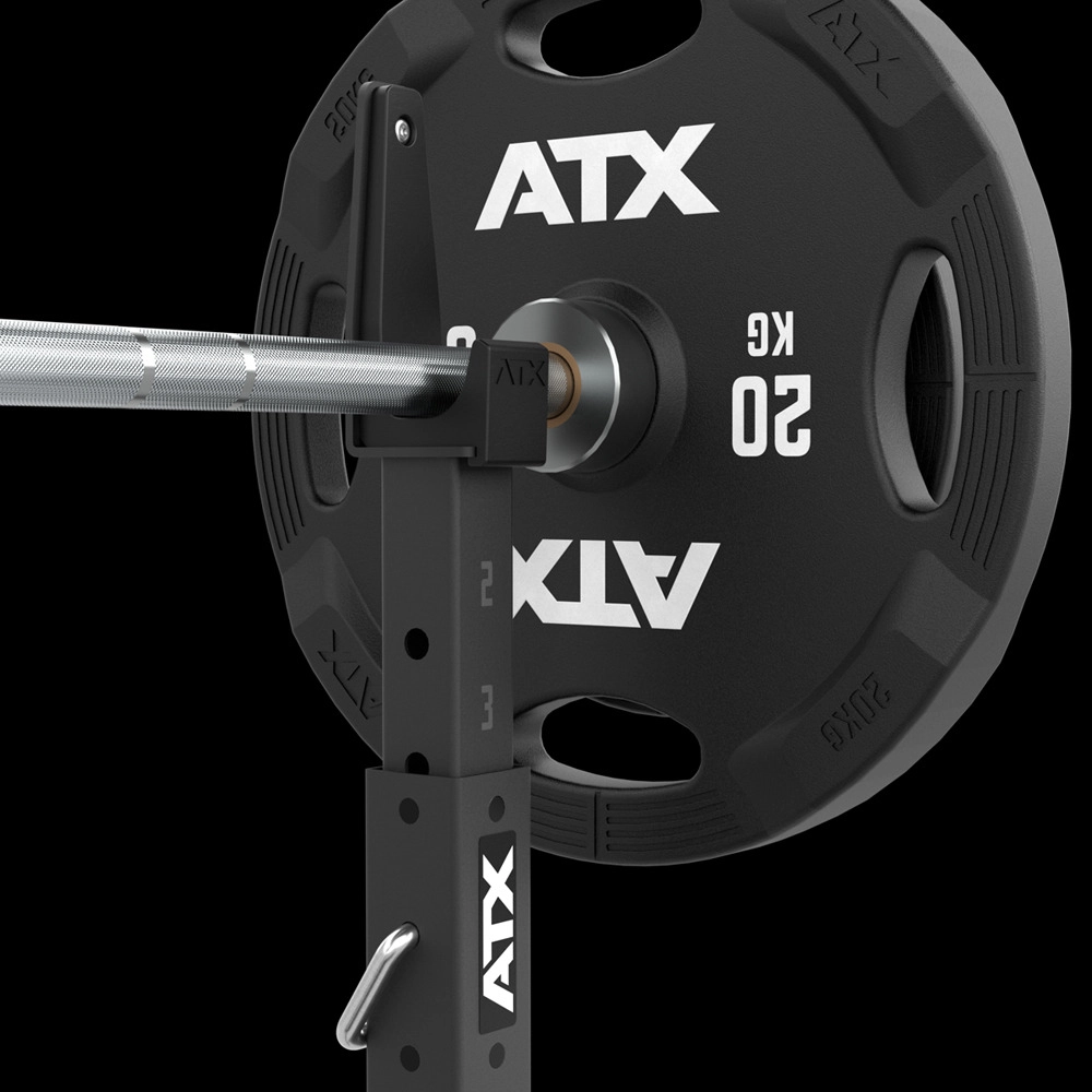Close-up of a loaded barbell on ATX® Squat Stands 510 for home gyms, featuring a black 20 kg ATX weight plate with bold white labeling and multiple grip handles. Bar and rack include visible measurement markings.
