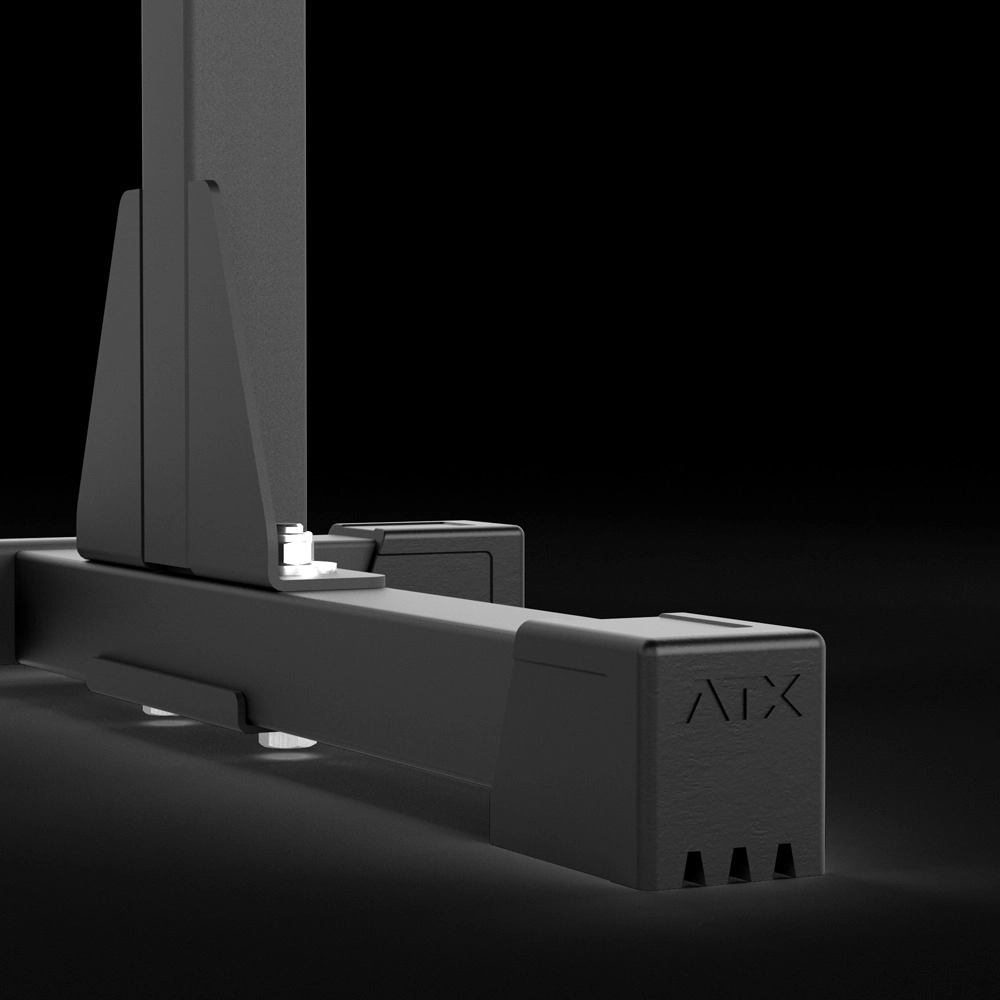 Close-up of the lower part of a black metal ATX® Squat Stands 510 with a sturdy base and bolts, featuring "ABX" engraved on the side—perfect for home gym setups against a dark background.