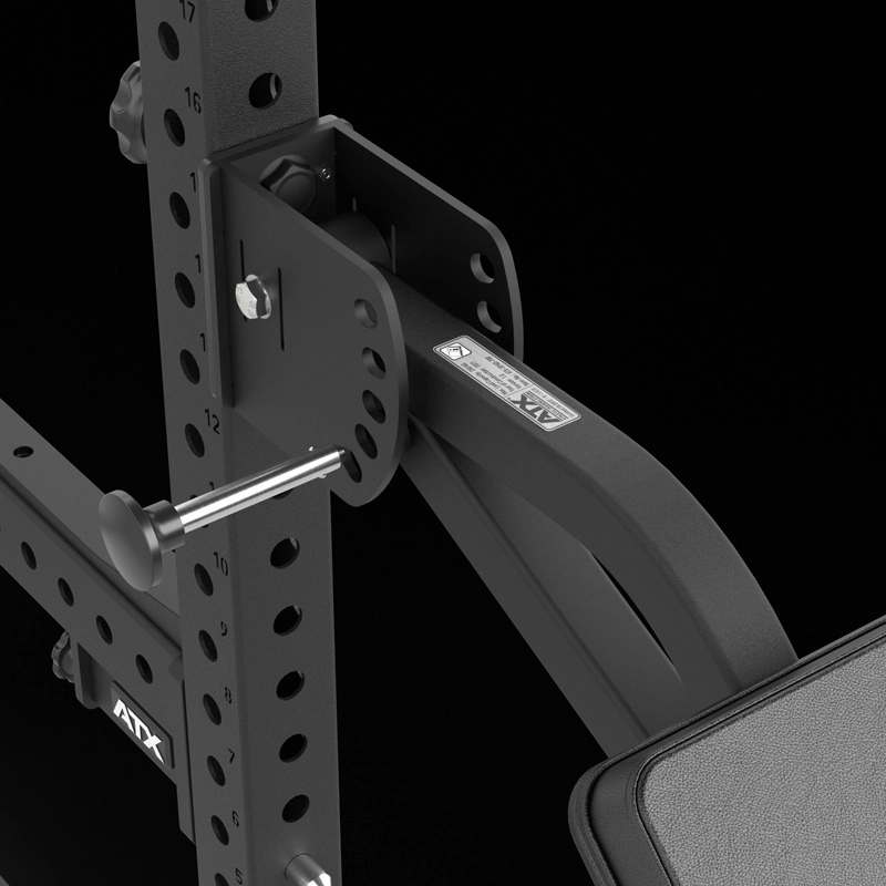 Close-up of the ATX® The Bridge Supporting Pad on a black adjustable weight bench, showing multiple position holes and a locking pin inserted into the sturdy metal frame, with the ATX logo visible against a black background.