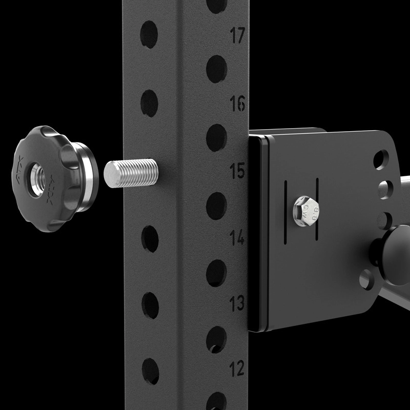 Close-up of an ATX® The Bridge Supporting Pad attached to a black metal gym rack with numbered adjustment holes, a large screw knob on the left, set against a plain black background.