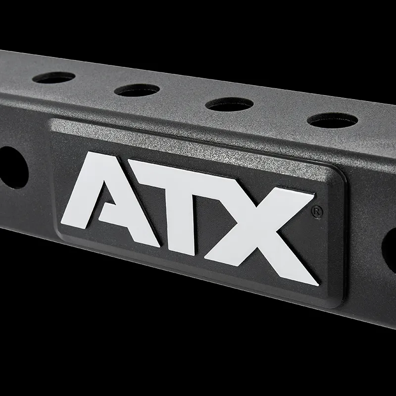 A close-up of the ATX® Belt Squat Option shows a black metal bar with multiple holes and a white ATX logo, set against a solid black background.