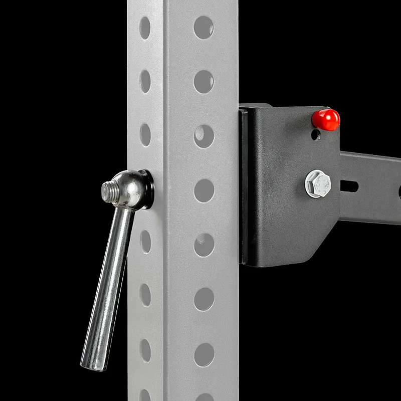 Close-up of the ATX® Belt Squat Option—steel frame with multiple adjustment holes, a metal pin inserted, and a black bracket attached with a red plastic knob and bolt, set against a black background.