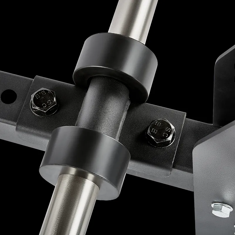 Close-up of metal rods and bolts assembled with black circular clamps against a black background, showing part of the ATX® Belt Squat Option gym equipment structure.