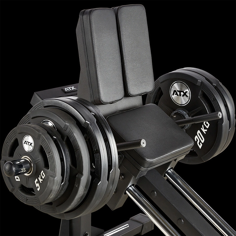 Close-up of the ATX® Compact Leg Press ATX-CLP-700 loaded with multiple weight plates, including visible 20 kg and 5 kg plates on each side. Padded back and seat supports ensure comfort during use.