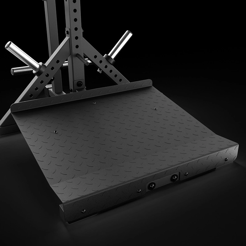 A close-up of the black, textured metal footplate on the ATX® Lever Arm Squat Pro - Viking Press, with weight plate storage pegs visible in the background against a dark backdrop.