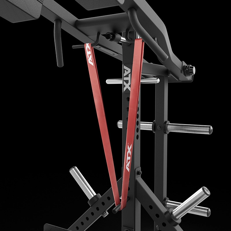 Close-up of the ATX® Lever Arm Squat Pro - Viking Press with red ATX resistance bands on its black frame, featuring multiple horizontal weight plate storage pegs, set against a black background.