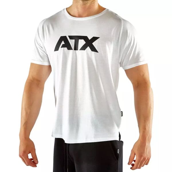 An individual is wearing an ATX® - T-Shirt White and is standing against a plain white background.