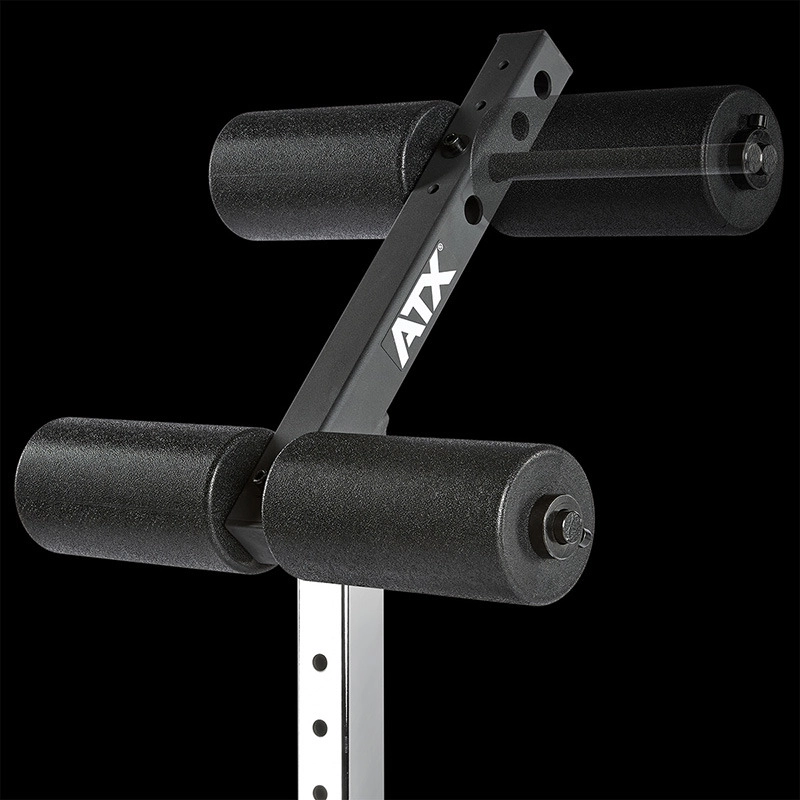 Close-up of the ATX® AB Attachment in black and silver, featuring four foam rollers arranged in a V-shape on a metal frame, set against a black background.