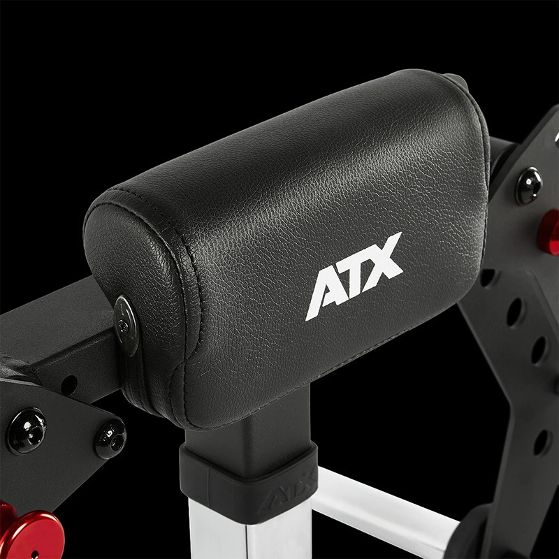 Close-up of the ATX® Pec-Fly Attachment—black padded support with white ATX logo—mounted on gym equipment with metal and red elements, set against a black background.
