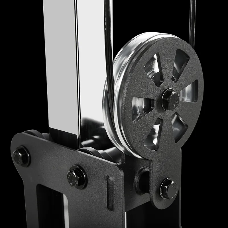 A close-up of the ATX® Pec Fly/Rear Delt Machine’s metal pulley system, featuring a grooved wheel and bolts, mounted on a black frame and set against a black background.