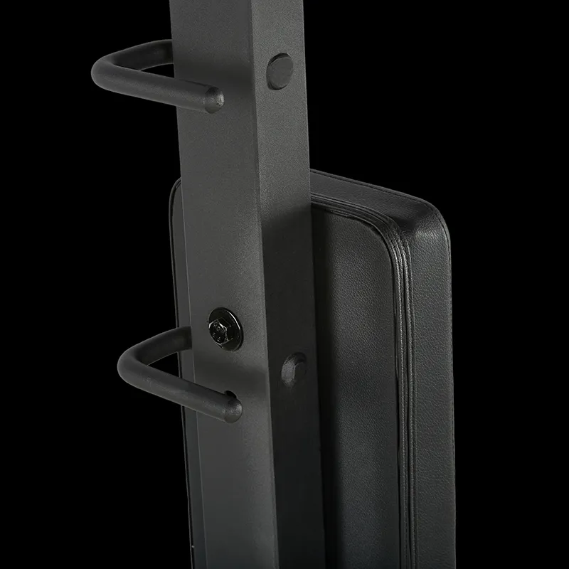 Close-up of the ATX® Pec Fly/Rear Delt Machine's black metal frame, featuring two protruding pegs and a padded black backrest, set against a solid black background.