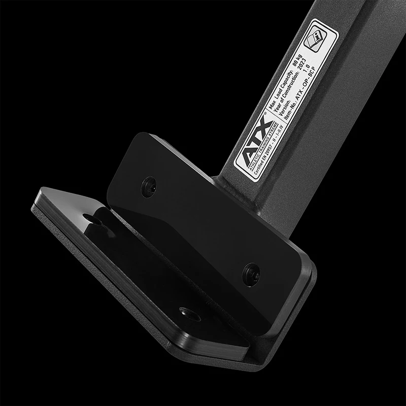 Close-up of a black metal ATX Bicep Curl Pad bench attachment featuring a warning label that lists the maximum load capacity and model information.