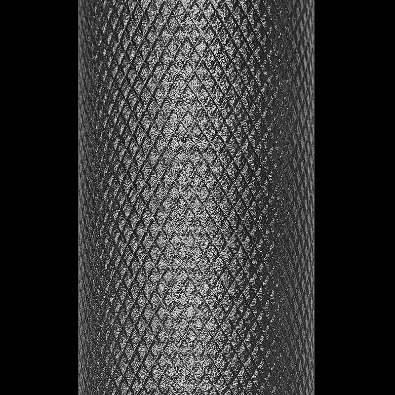 Close-up of the ATX® Cambered Swiss Bar 50mm’s diamond-shaped knurled pattern, designed for enhanced grip and traction. The metallic texture stands out against the black background.