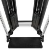 Close-up view of a dual adjustable pulley gym machine with weight stacks and a footplate. The metal frame has multiple adjustment holes and cable pulleys on each side, set against a white background.