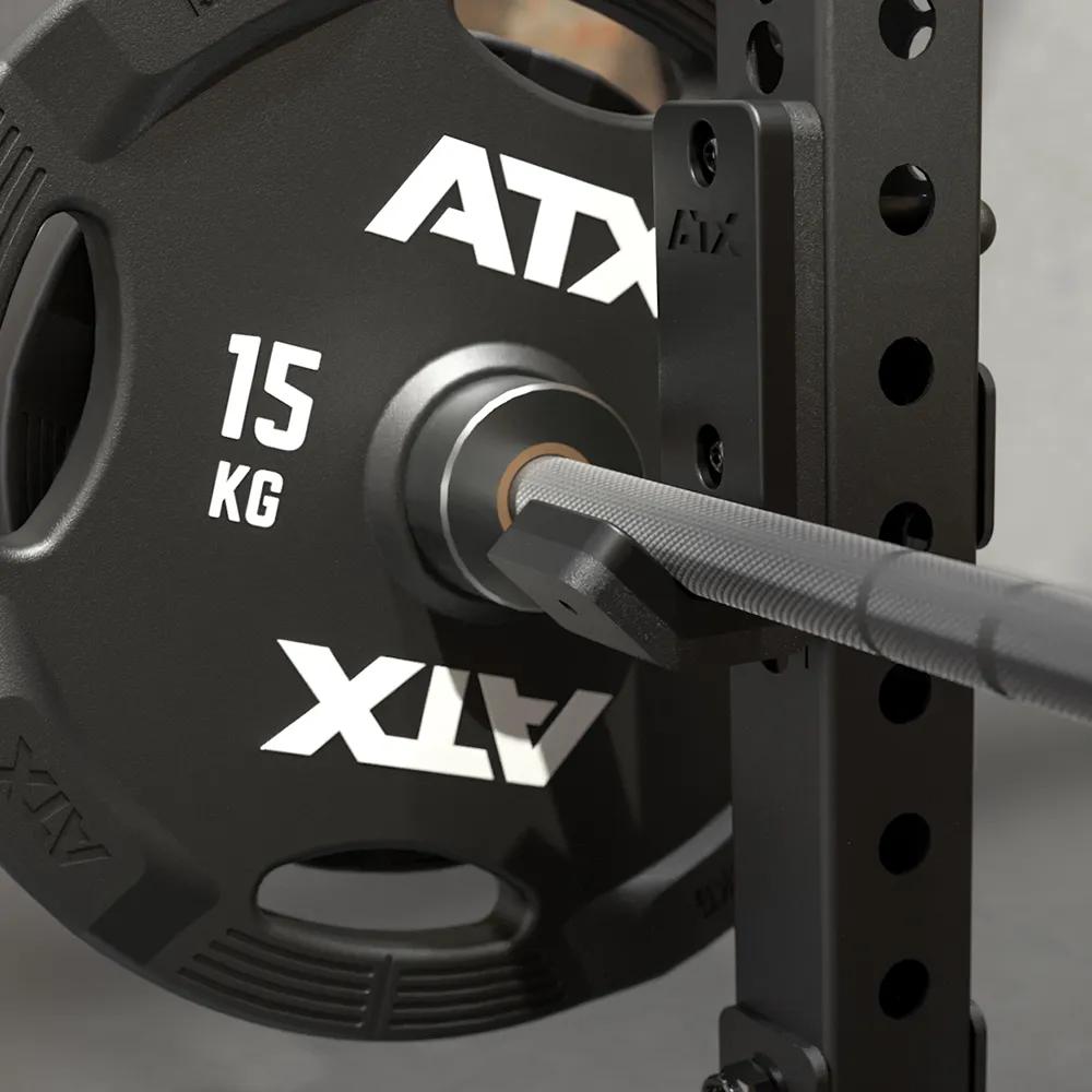 Close-up of a black 15 kg weight plate on a barbell resting on the ATX® Seal Row Bench, part of a gym setup with fitness equipment.