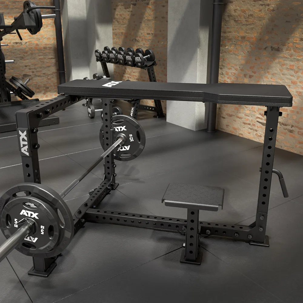 The ATX® Seal Row Bench, featuring a black adjustable design with a loaded barbell and weights, stands in a modern gym with brick walls, rubber flooring, and a background rack of dumbbells.