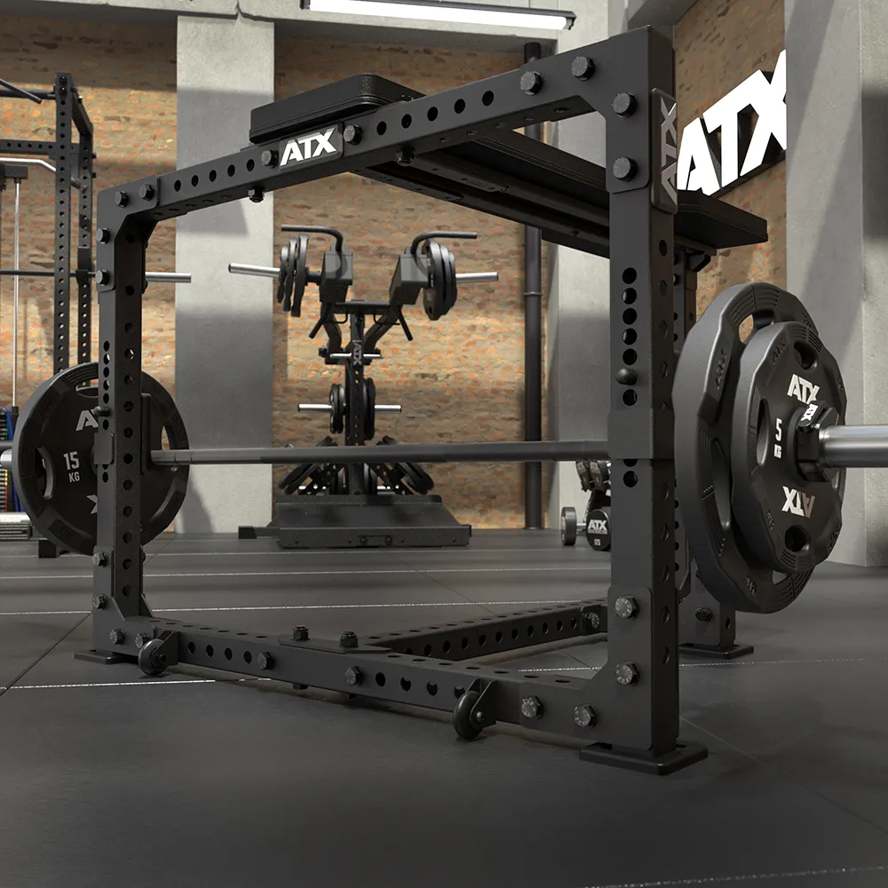 An ATX® Seal Row Bench with a loaded barbell sits in a gym, surrounded by weight plates, various gym equipment, and exposed brick walls in the background.