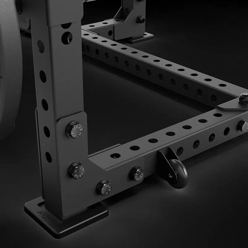 Close-up view of the ATX® Seal Row Bench metal frame with multiple adjustment holes, bolts, and a black safety pin on a dark background, typically used for strength training or weightlifting.